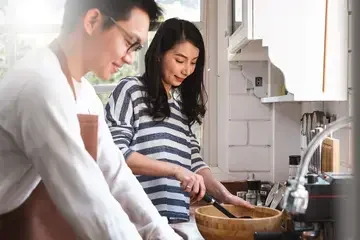 Asian couple family cooking food together in kitchen