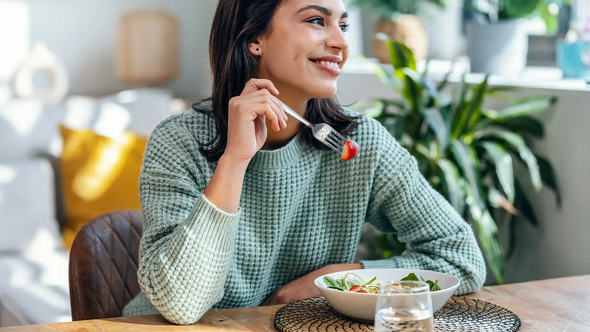 Beautiful-smiling-woman-eating-healthy-salad-at-home