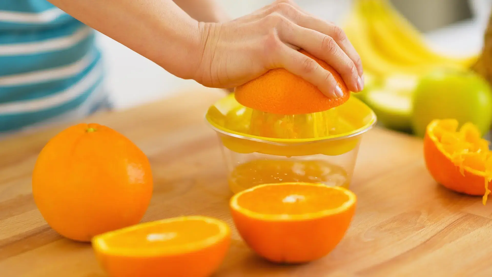 Closeup on woman making orange juice