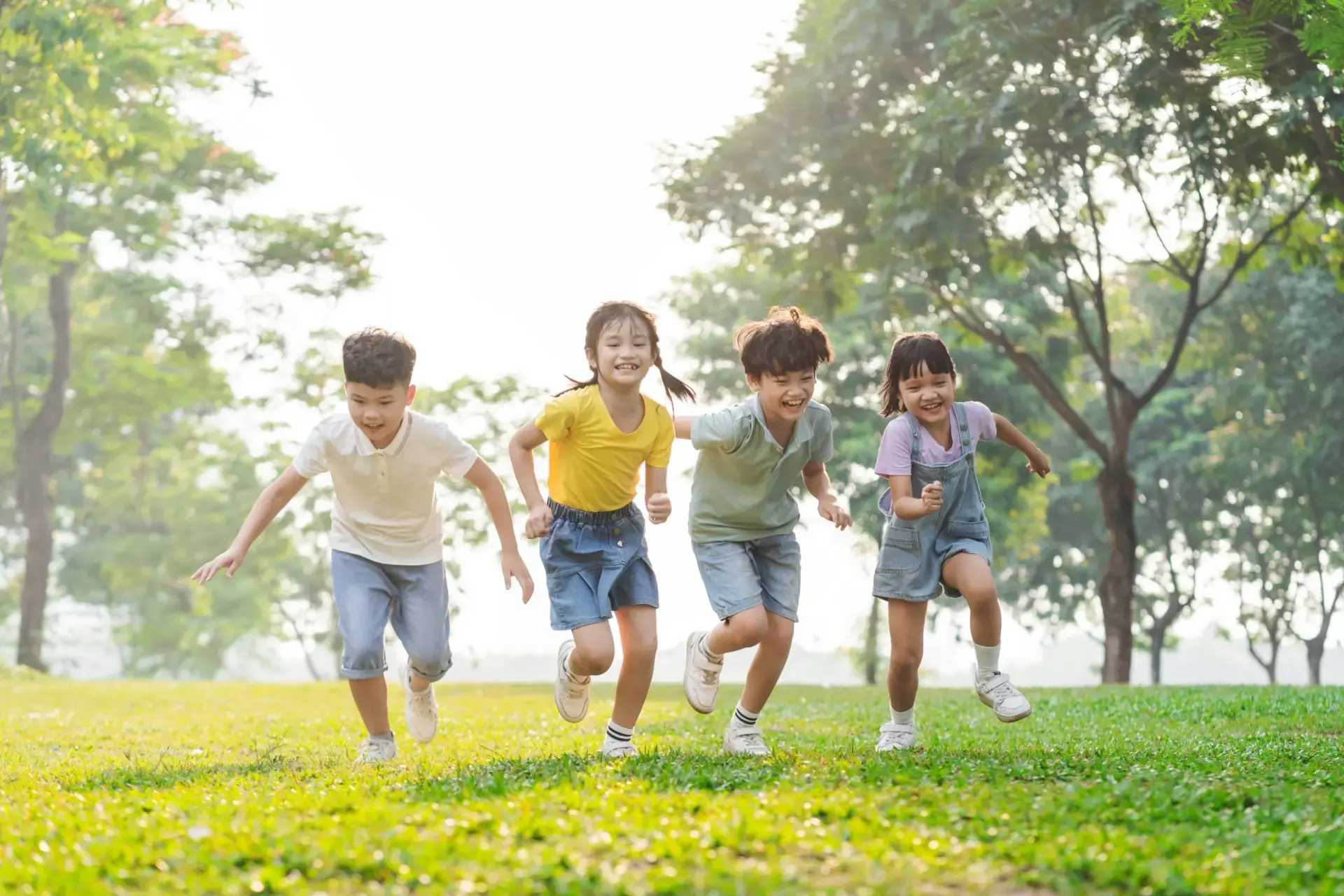 Isang grupo ng mga Asyanong bata na masayang nagtatakbuhan sa parke.