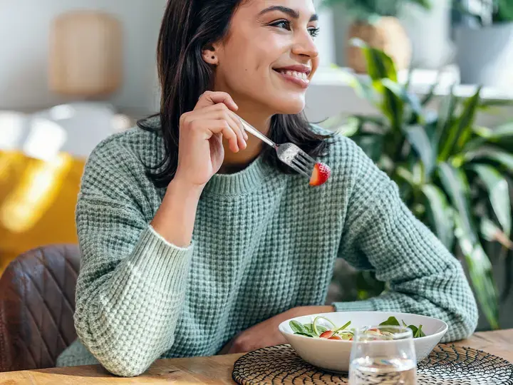 Beautiful-smiling-woman-eating-healthy-salad-at-home