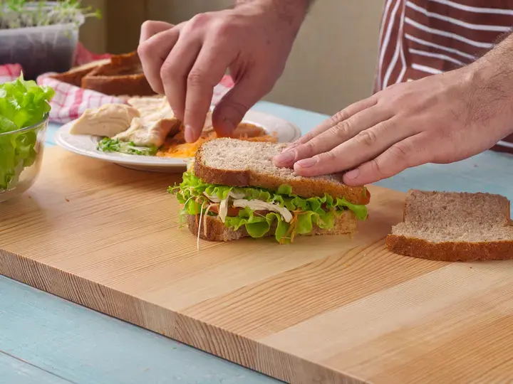 Man cooking big sandwich with chicken