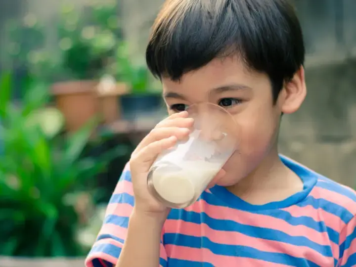 Batang Asyano na umiinom ng isang glass of milk.