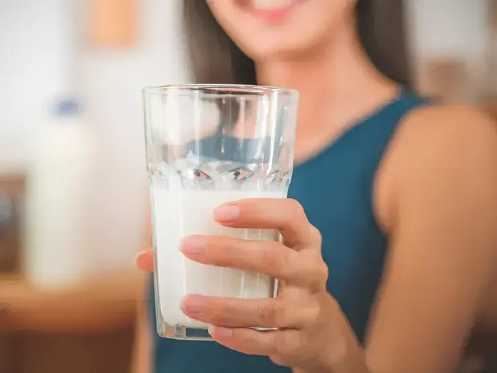 Asyanong babae na may hawak na isang basong gatas.