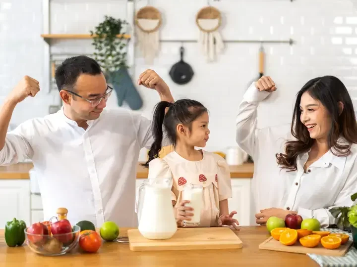 Isang pamilyang masayang umiinom ng gatas sa almusal.